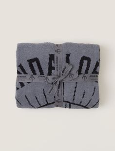 Show your love for the best bounty hunter in the galaxy with our new Mandalorian™ blanket. Knit detailing shows the Mandalorian's iconic helmet while the jacquard pattern creates an extra cozy feel, making it the perfect piece to snuggle up with while watching all your favorite Star Wars™ moments. Packaged and tied with custom Star Wars ribbon, this item is perfect for gifting.   This style is not eligible for promotional discounts. Disney Blanket, Star Way, Long Cardi, Women's Henley, Elegant Drapes, Pink Clay, Cozy Pullover, Jacquard Pattern, The Mandalorian