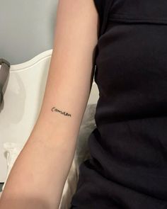 a woman's arm with a small tattoo that says contempl on it