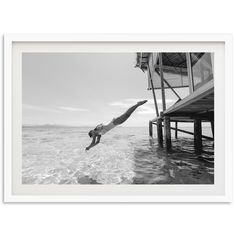 a black and white photo of a person diving into the water