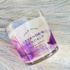 a candle that is sitting on top of a fur rug with the words lavanda and sandalo written in it