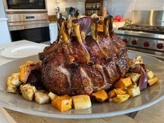 a large piece of meat sitting on top of a plate next to potatoes and carrots