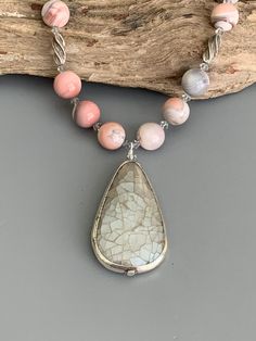 Look your best wearing this Agate necklace jewelry set!  The handmade pendant necklace and dangle earrings feature pink Botswana Agate stones, light gray crystals and silverplated components.  The beaded necklace is approximately 18 inches long and the earrings are 2.25 inches long.  The crackled gray teardrop pendant is approximately 2 inches long.  The necklace closes securely with a heart shaped, silver-plated toggle clasp.  The earrings are connected to simple, sterling silver ear wires.  The set will be a welcome addition to your jewelry collection or a lovely gift idea for someone. Available as clip on earrings, use the drop down menu to choose your option. This jewelry set is designed and handmade by me, Sharon, of Blonde Peach Jewelry. It will arrive in an attractive organza bag th Handmade Silver Agate Beaded Necklaces, Silver Beaded Necklace With Stones, Bohemian Gray Dangle Jewelry, Silver Agate Gemstone Beaded Necklaces, Silver Agate Gemstone Beaded Necklace, Silver Beaded Necklace With Natural Stone Pendant, Silver Beaded Pendant Necklace With Natural Stones, Silver Beaded Teardrop Pendant Jewelry, Silver Pendant Beaded Necklace With Natural Stones