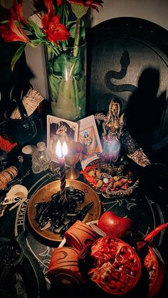 a table topped with candles and cards next to a vase filled with flowers