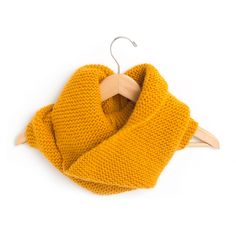 a yellow scarf hanging on a wooden hanger