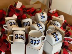 a pile of coffee mugs with numbers on them sitting in front of some boxes