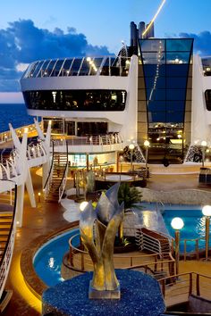 a cruise ship with a swimming pool and stairs leading up to the top deck area