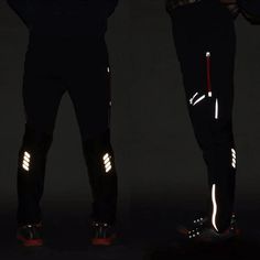 two people standing in the dark with their feet on skis and one is wearing reflective gear