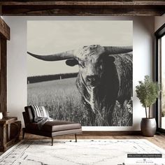 a cow standing in the middle of a living room with a large wall mural behind it