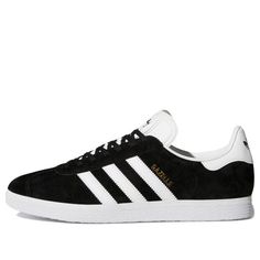 The adidas Gazelle 'Black' is a timeless classic that has been around since 1968. Originally designed as a training shoe, the Gazelle has become a favorite of handball and indoor soccer players. Now, the Gazelle is back in a sleek black and white colorway. Crafted with a premium leather upper and a rubber sole, the Gazelle is both stylish and comfortable. The iconic three-stripe logo and gold Gazelle lettering on the side give the shoe a classic look. Whether you're running errands or going out Classic Black Sneakers With Three Stripes, Classic Adidas Sneakers For Sports, Casual Training Sneakers With Three Stripes, Adidas Gazelle Black, Indoor Soccer, Adidas Gazelle, Training Shoes, Stylish Sneakers, Soccer Players