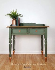 a green table with two drawers and a potted plant on top