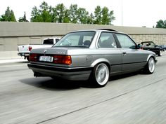 a silver car driving down a street next to other cars