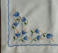 an embroidered handkerchief with blue flowers on it