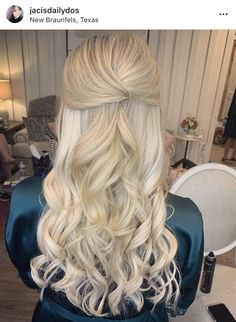 the back of a woman's head with long blonde hair in a half updo