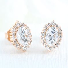 a pair of diamond earrings on a white surface