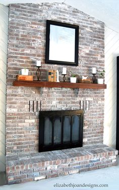 a living room with a brick fireplace and white walls