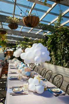 a table set up with balloons and place settings