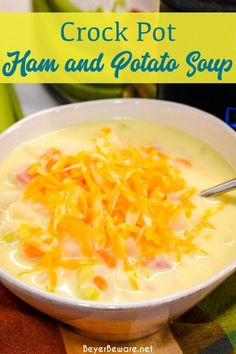 crock pot ham and potato soup in a white bowl with a spoon on the side