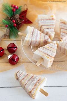 several pieces of cake sitting on top of a glass platter next to christmas decorations