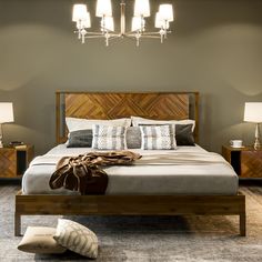 a bedroom with a bed, nightstands and two lamps on the side of it