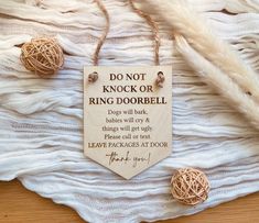 a wooden sign that says do not knock or ring doobell on it next to some fake feathers