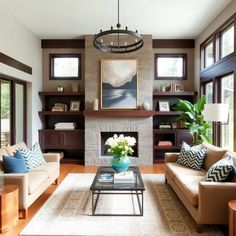 a living room with two couches and a coffee table in front of a fireplace