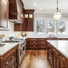 a large kitchen with wooden cabinets and white counter tops, along with hardwood flooring