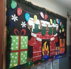 a christmas bulletin board is decorated with presents and stockings on the fireplace, along with holiday lights