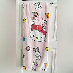 a hello kitty towel hanging on a door with an easter bunny and bunnies pattern