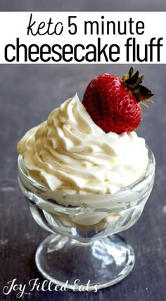 a glass bowl filled with whipped cream and a strawberry on top