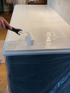 a person is using pliers to cut up the top of a white countertop