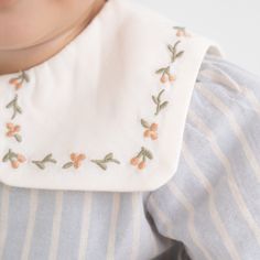 a close up of a baby wearing a bib with flowers on it's chest