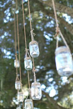 mason jars hanging from rope with trees in the background