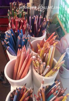 there are many different colored pencils in cups