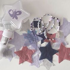 a star shaped object next to other items on a white surface with purple and pink stars