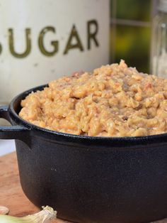 a close up of a bowl of food on a table next to a bottle of sugar