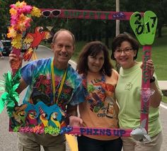 three people standing in front of a pink sign that says finish up on the street