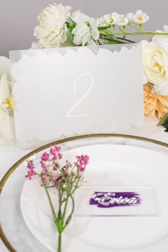 a table setting with flowers and place cards