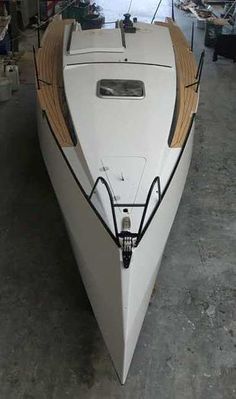 a white boat sitting in a garage next to other boats