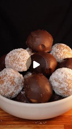 a white bowl filled with chocolate covered donuts