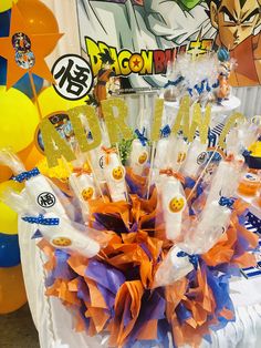 a table with balloons and decorations for a dragon ball birthday party on it's table