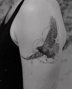 a black and white photo of a woman's arm with a bird tattoo on it