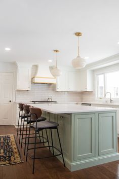 a kitchen with an island and stools in it