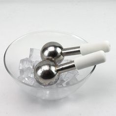 two silver and white balls in a glass bowl