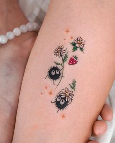 a close up of a person's legs with tattoos on them and flowers in the background