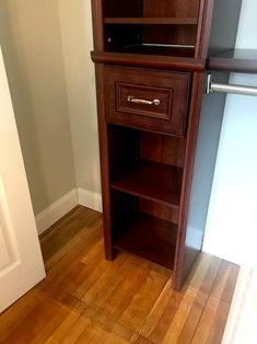 a tall wooden cabinet sitting on top of a hard wood floor