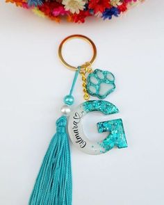 a keychain with the number five on it and a tassel hanging from it