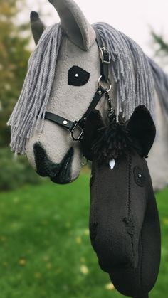 a stuffed horse head hanging from the side of it's face with a black hat attached to it