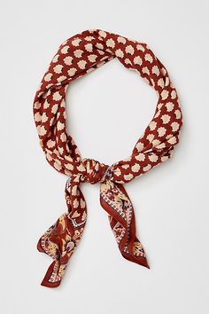 a red and white scarf with an animal print on the front, tied to a headband