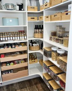 an organized pantry with wooden bins and baskets