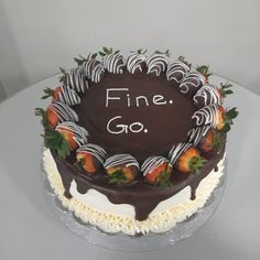 a chocolate cake with strawberries on top and the words fine go written on it